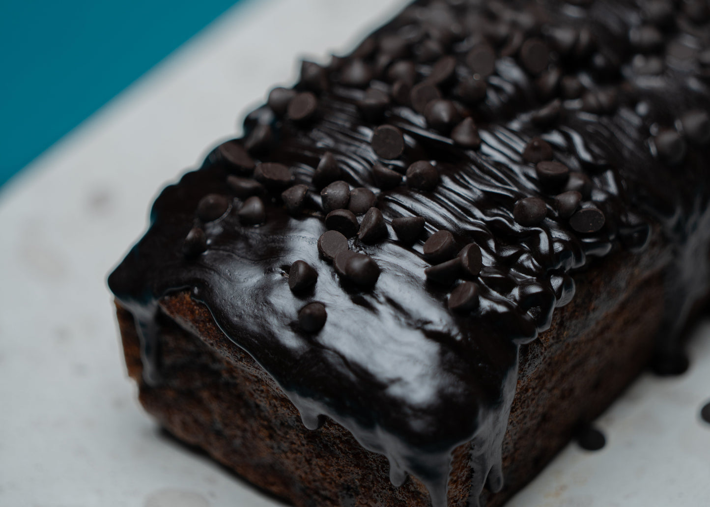Chocolate loaf cake with chocolate chips on a white plate