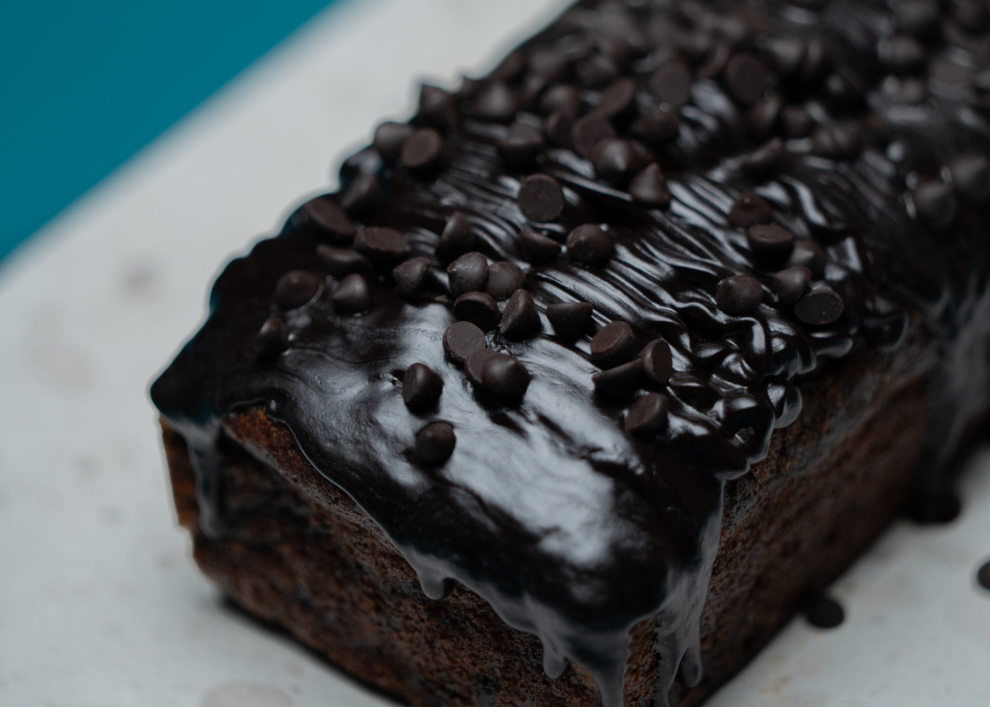 Chocolate loaf cake with chocolate chips on a white plate