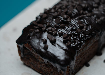 Chocolate loaf cake with chocolate chips on a white plate