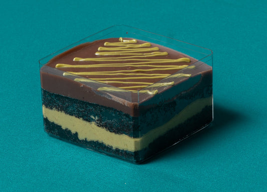 Layered dessert with chocolate and gold drizzle on a teal background